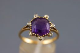 A yellow metal dress ring set with a cushion faceted cut amethyst measuring approximately 9.