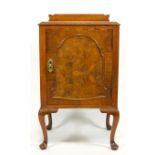 A walnut bed side cabinet with arched panel to door and cabriole legs,