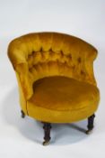 A Victorian tub shaped nursing chair, with button back, on turned mahogany legs with casters,