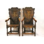 A pair of 17th century style oak chairs, each with carved panelled backs,