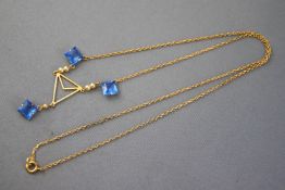 A gold plated centrepiece necklace suspended from a trace link chain.