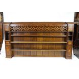 An oak dresser rack, in George III style, with unusual pierced frieze above three open shelves,