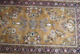 A Sarough rug with flowers on a mauve ground within one wide border,