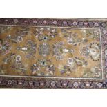 A Sarough rug with flowers on a mauve ground within one wide border,