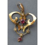 A yellow metal abstract pendant set with commercial quality rubies and seed pearls.