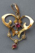 A yellow metal abstract pendant set with commercial quality rubies and seed pearls.