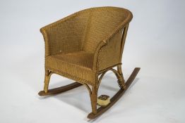 A child's Lloyd Loom stye rocking chair with a musical movement,