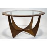 A G-plan teak and glass topped coffee table, of circular form with raised curved supports,