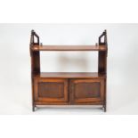 A Victorian mahogany hanging wall shelf, with two tiers above two panelled doors,