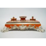 An early 19th century English porcelain desk set, of rectangular form, decorated in orange and gilt,