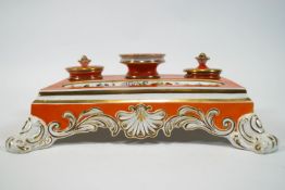 An early 19th century English porcelain desk set, of rectangular form, decorated in orange and gilt,