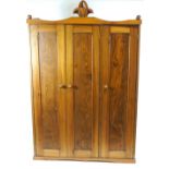 A cedar wood wardrobe with three panelled doors,