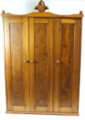 A cedar wood wardrobe with three panelled doors,