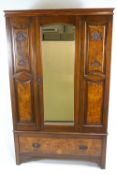 A late Victorian walnut wardrobe with one mirrored door above a drawer on bracket feet.