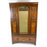 A late Victorian walnut wardrobe with one mirrored door above a drawer on bracket feet.