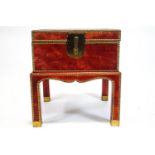 A red leather covered box on stand, with two brass handles and brass studs,