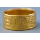 A yellow metal flat profile wedding ring. Engraved finish. No hallmark - tests indicate 22ct gold.