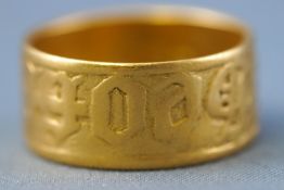 A yellow metal flat profile wedding ring. Engraved finish. No hallmark - tests indicate 22ct gold.