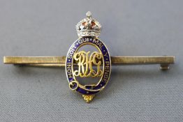 A yellow and white metal royal horse guards bar brooch.