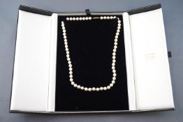 A collection of two items to include: A single strand pearl necklace consisting of sixty five 6.