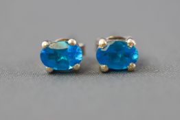 A white metal pair of single stone stud earrings,