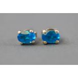 A white metal pair of single stone stud earrings,