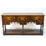 An oak dresser base in George III style with an arrangement of six drawers,