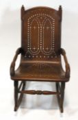 An American rocking chair, with open elbow arms, pierced one piece seat and back,