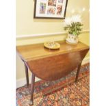 An early George III mahogany oval drop leaf table on turned tapering legs,