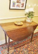 An early George III mahogany oval drop leaf table on turned tapering legs,