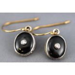 A yellow and whiter metal pair of drop earrings each having an oval pendant drop set with onyx and