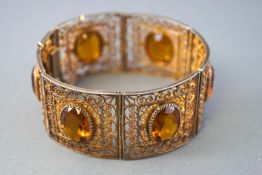 A silver gilt 30mm wide filigree panel bracelet set with oval faceted cut orange quartz.