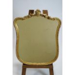 A carved gilt wood framed bevelled wall mirror of waisted form with foliate cresting in a rope work