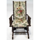 A late 19th century American rocking chair, with turned frame to an upholstered back and seat,