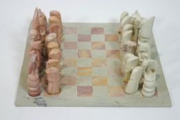 A Kenyan carved soapstone chess set, the King approximately 13.