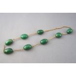 A yellow metal belcher chain necklace having eight oval polished aventurine quartz beads