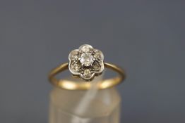 A yellow metal abstract cluster ring set with round brilliant cut diamonds,