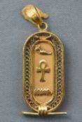 A yellow metal Egyptian cartouche pendant.