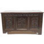 A 17th century oak coffer with later carved triple panelled front,