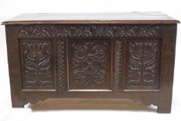 A 17th century oak coffer with later carved triple panelled front,