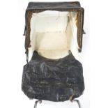 An early/mid 20th century child's dolls pram with folding over a deep body on a suspended base with