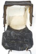 An early/mid 20th century child's dolls pram with folding over a deep body on a suspended base with