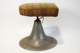 An adjustable stool, with conical metal base and tartan upholstered seat,