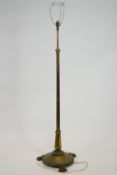 A brass telescopic standard lamp, on round base with three paw feet,