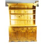 A 20th century pine dresser, the base with 3 drawers above 3 conforming panelled doors,