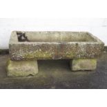 A large carved stone trough on stone base,