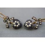 A yellow and white metal pair of drop earrings, styled as a heart design and set with sapphires,