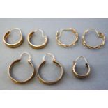 A collection of three pairs and one single yellow metal hoop earrings,