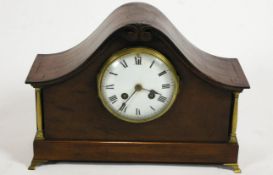 A 19th century mahogany cased mantel clock with arched top, brass columns and feet,