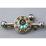 A white metal Russian bar brooch stylized as a circle centre with a turquoise set crescent.